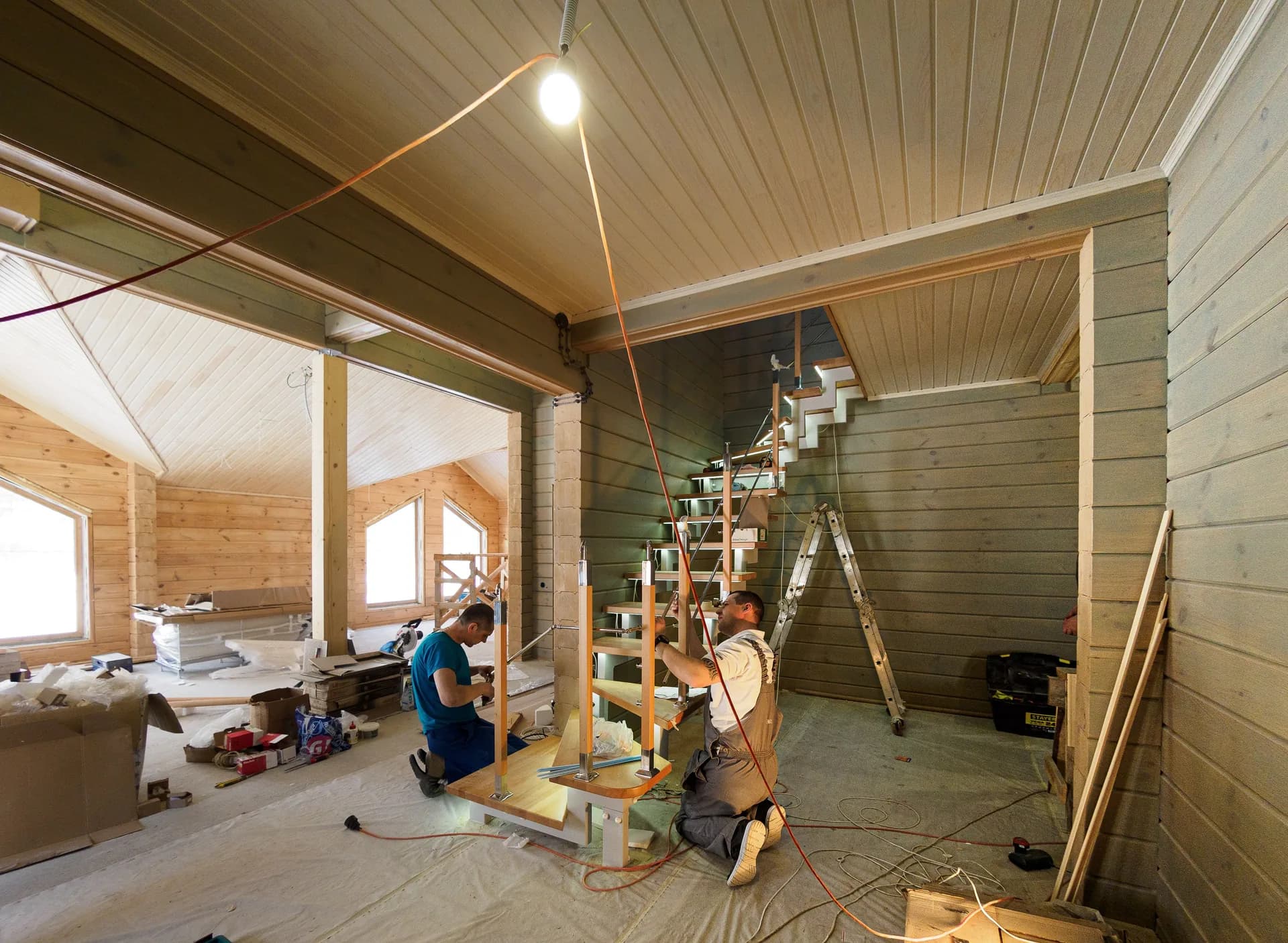 Workers renovating a wood-paneled interior
