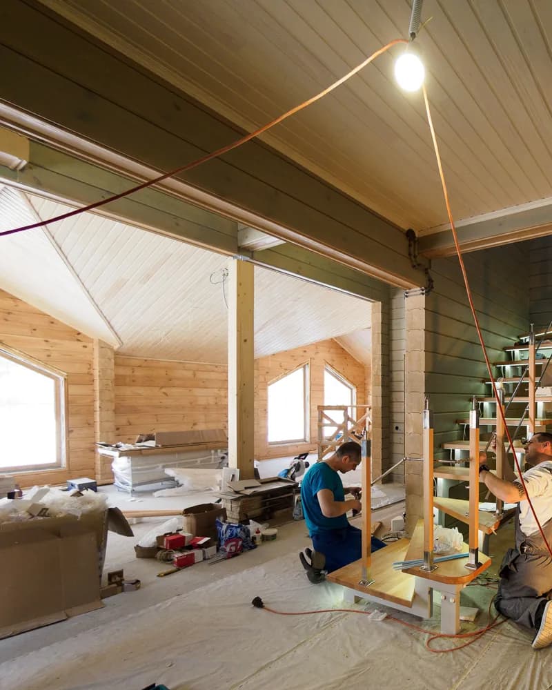 Workers renovating a wood-paneled interior